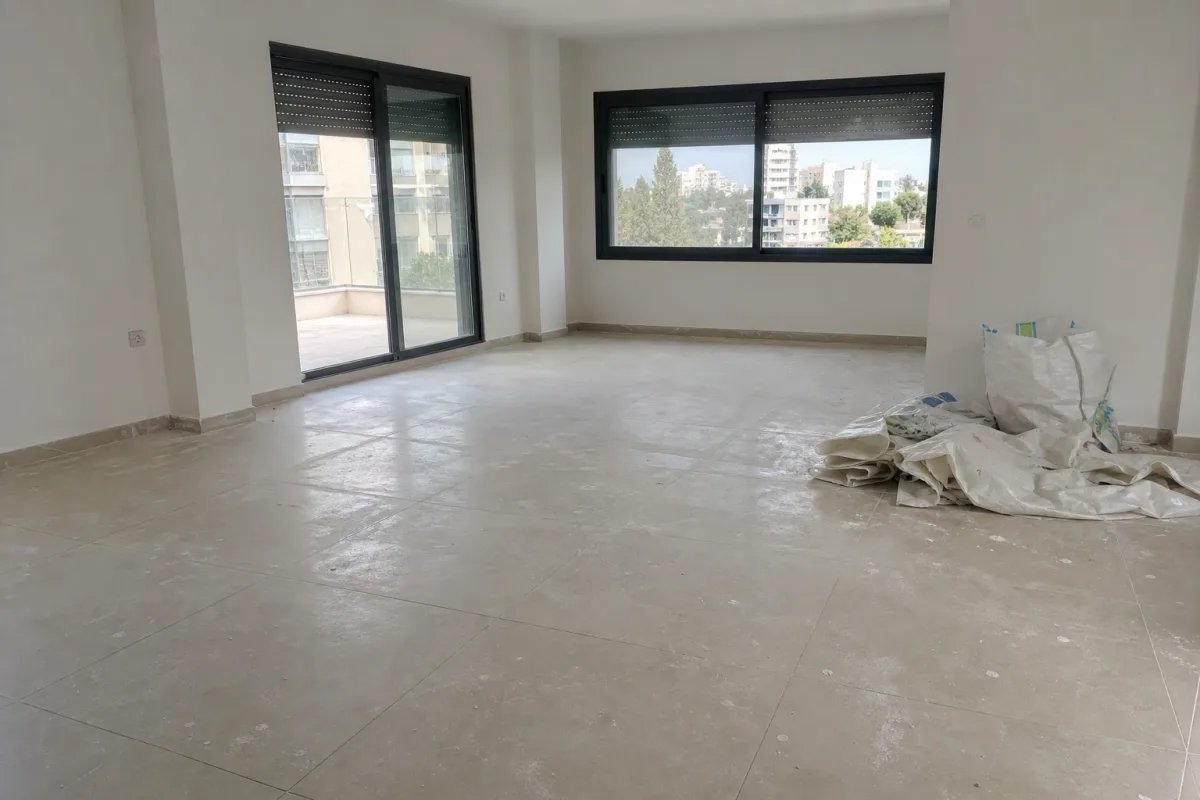 דירה ריקה עם אבק בנייה ושאריות צבע קלות לאחר שיפוץ